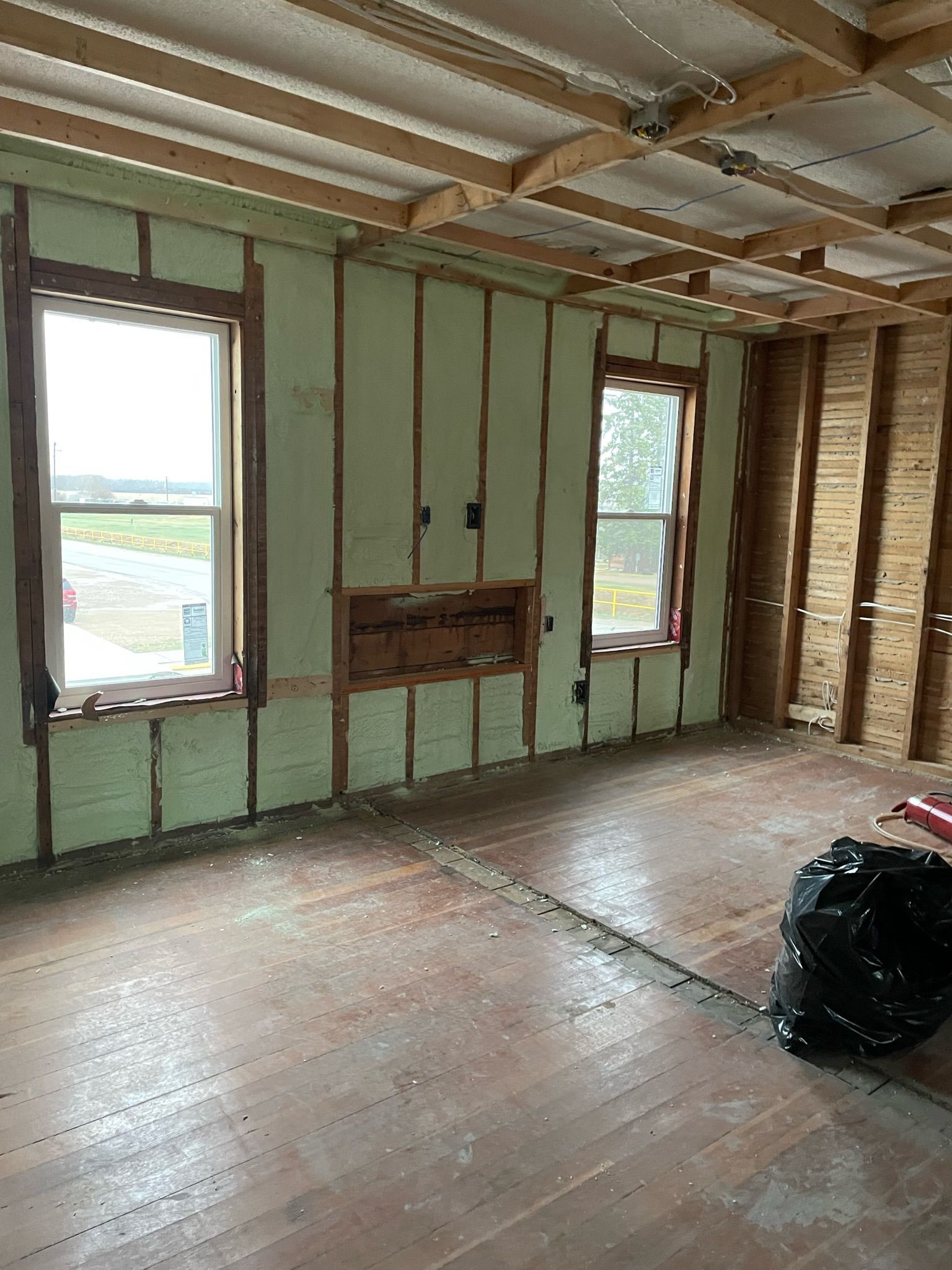 A room with a lot of windows and a wooden floor.