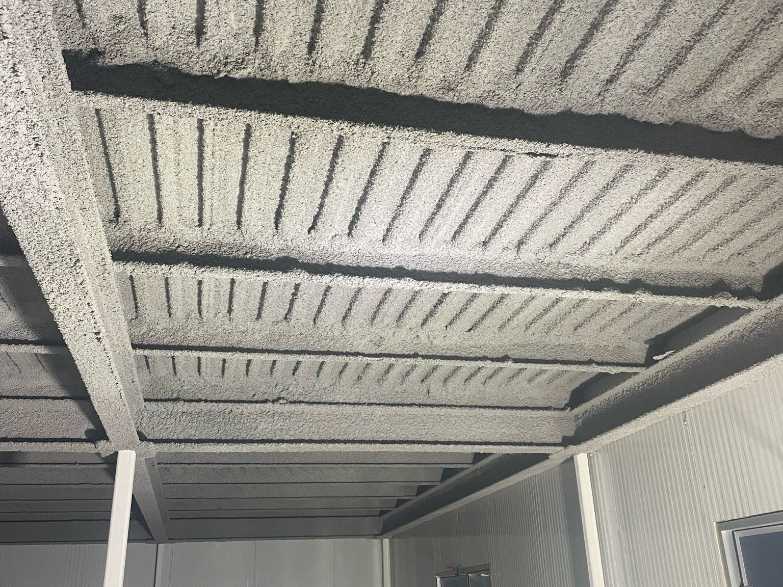 A room with a ceiling that has been spray painted white.