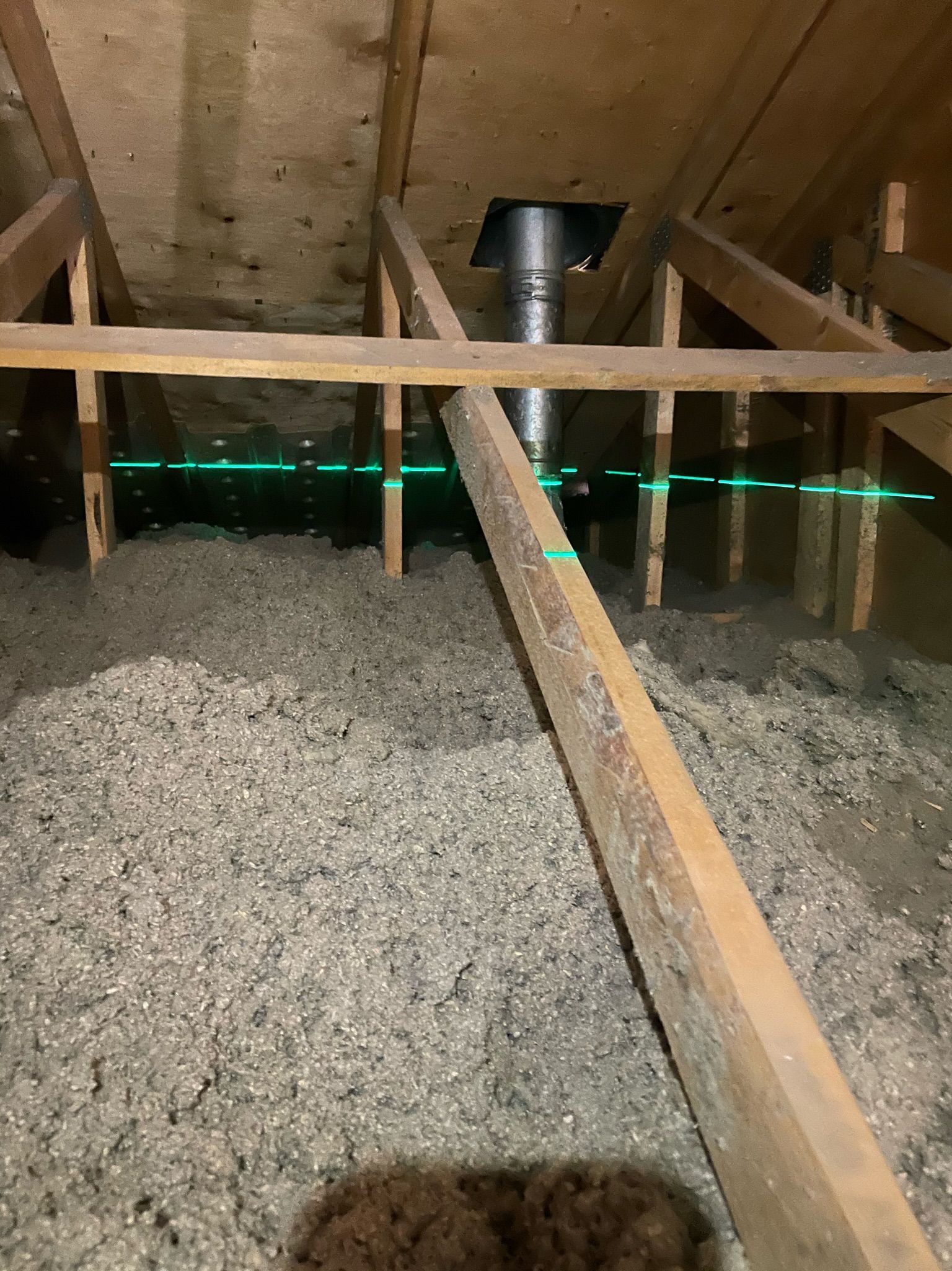 An attic with a chimney and a lot of insulation.