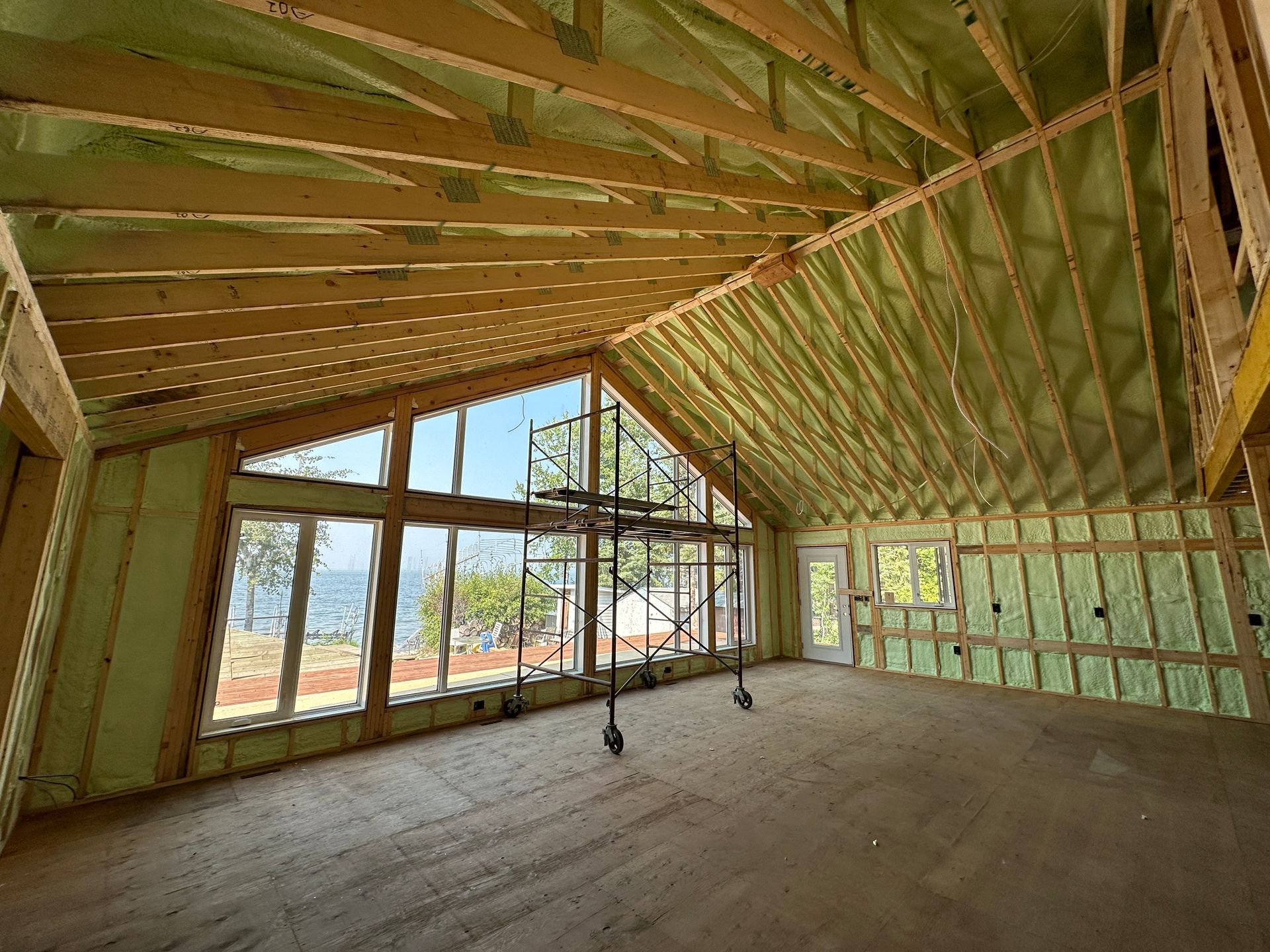 A large room with a lot of windows and insulation on the ceiling.