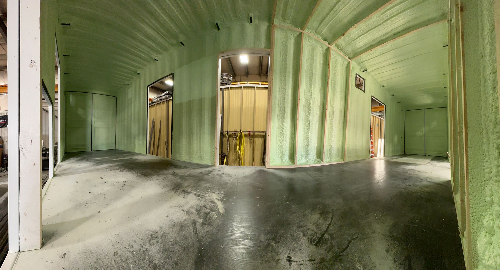 A large room with green walls and a concrete floor.