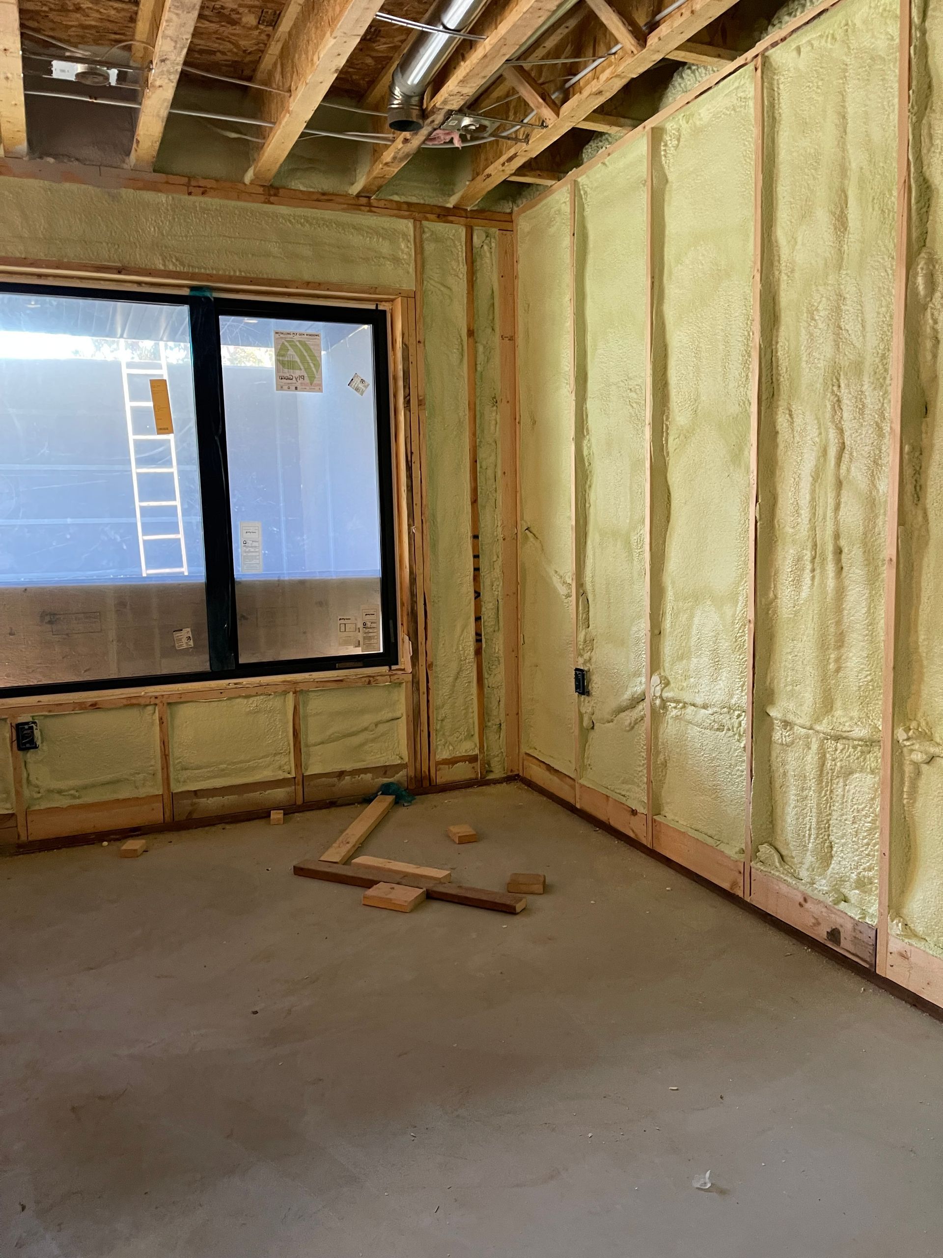 A room with wooden beams and foam insulation on the walls.