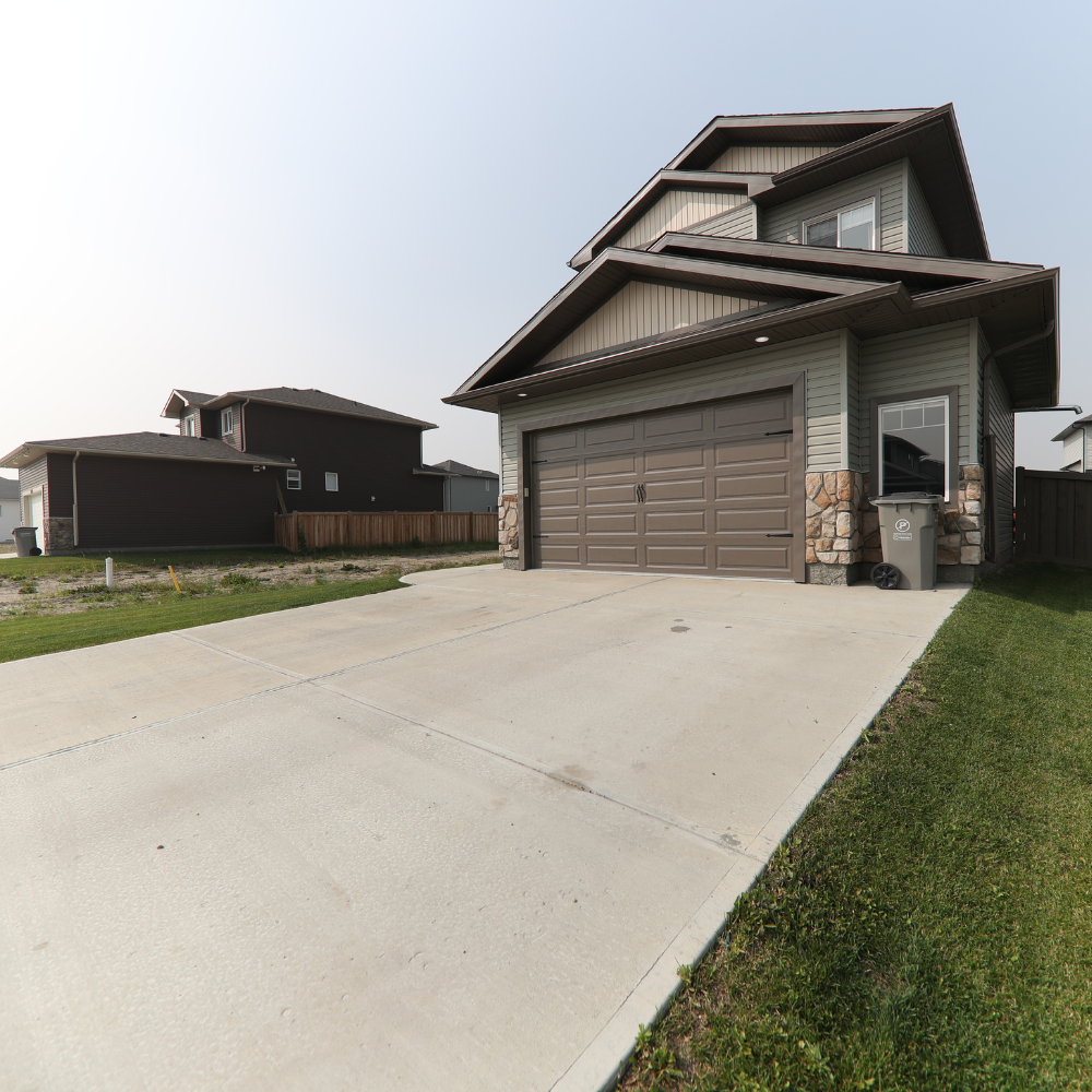 A large house with a concrete driveway leading to it