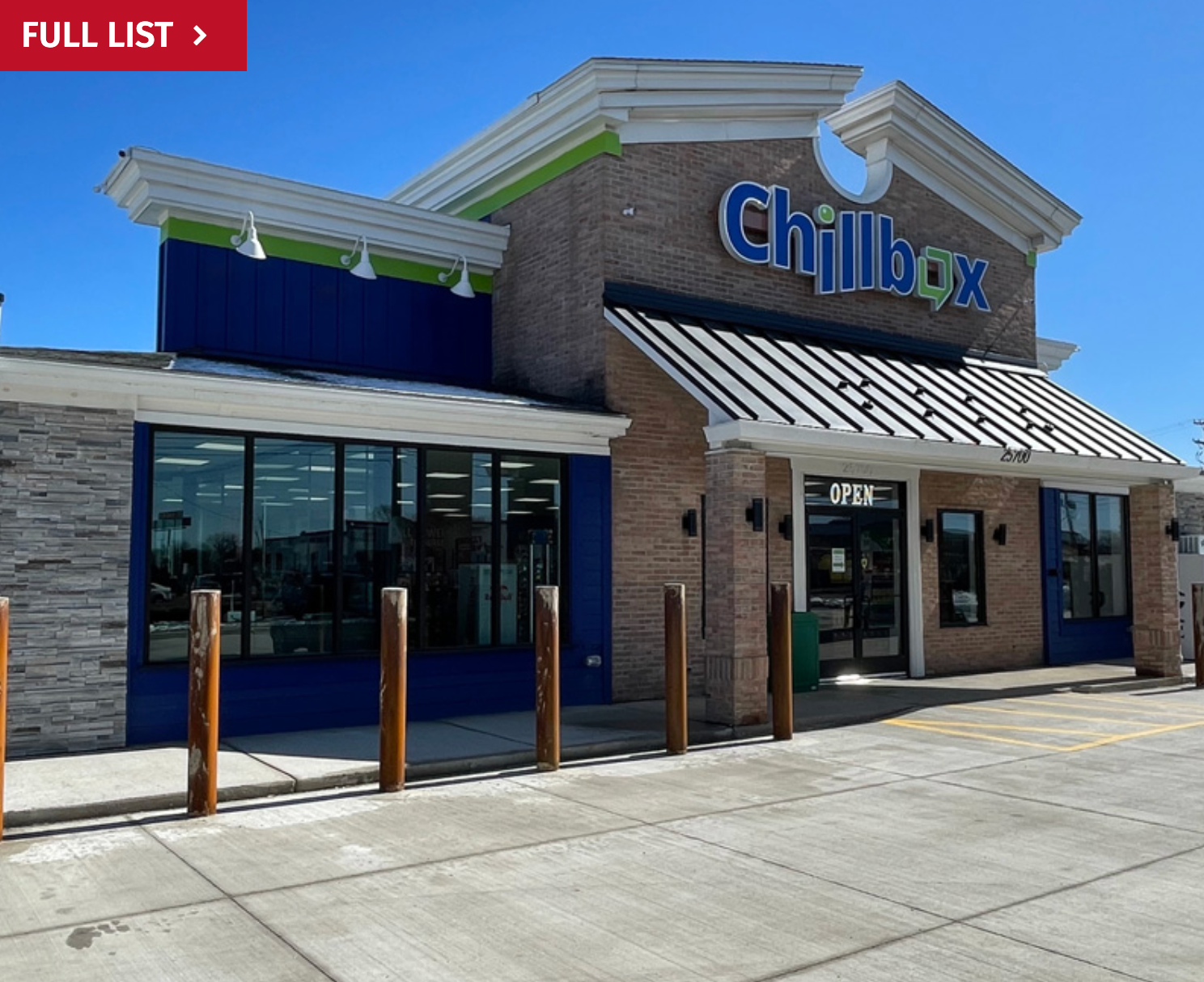 Chillbox storefront with brick facade, blue accents, and large windows on a sunny day