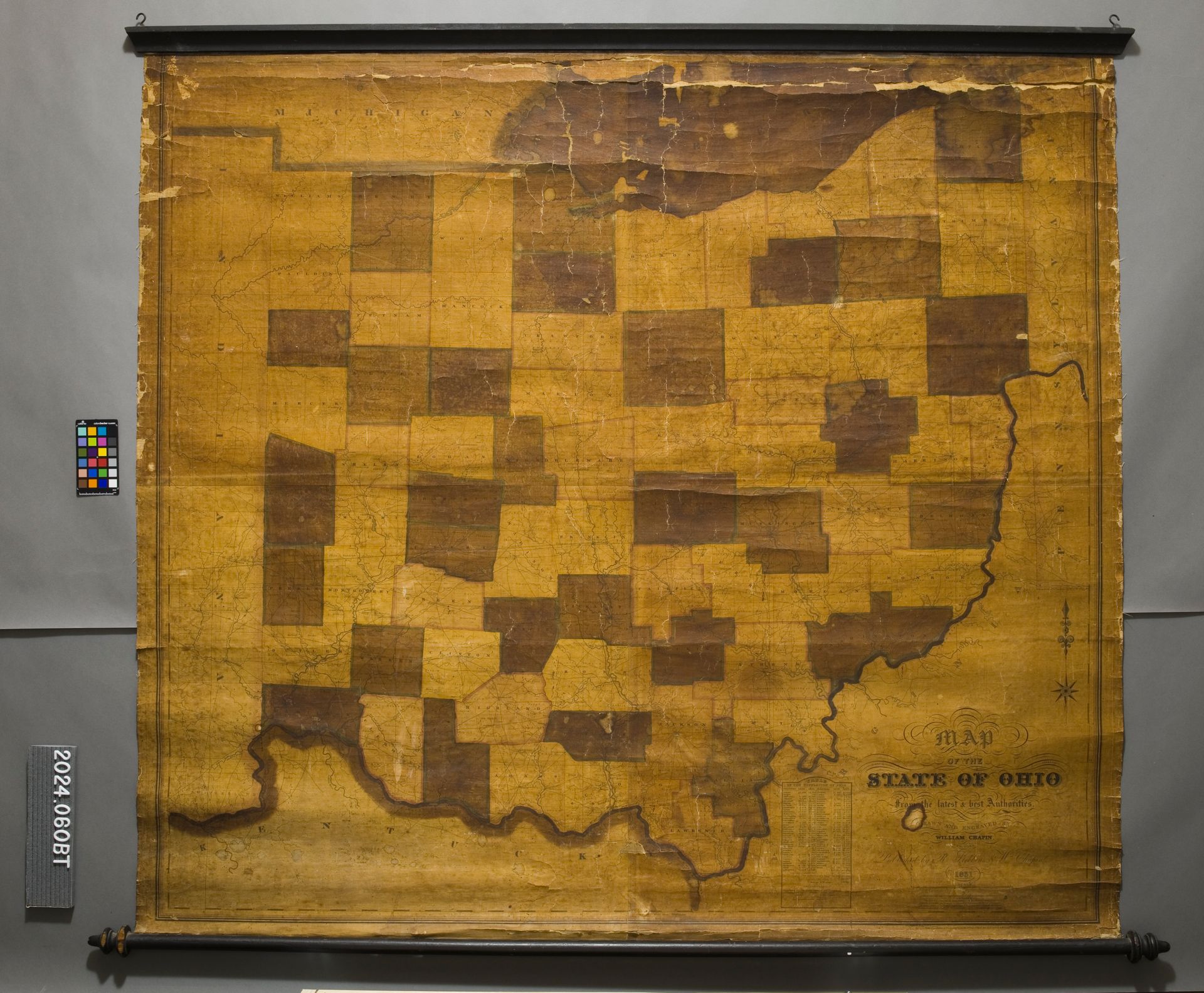 An antique, weathered wall map of Ohio, featuring a checkerboard pattern of dark and light brown county outlines.