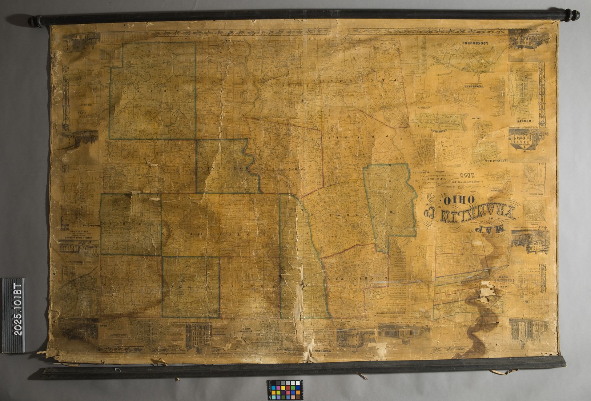 An open book with Japanese text, a color chart, and a woodblock print of figures in a patterned room.