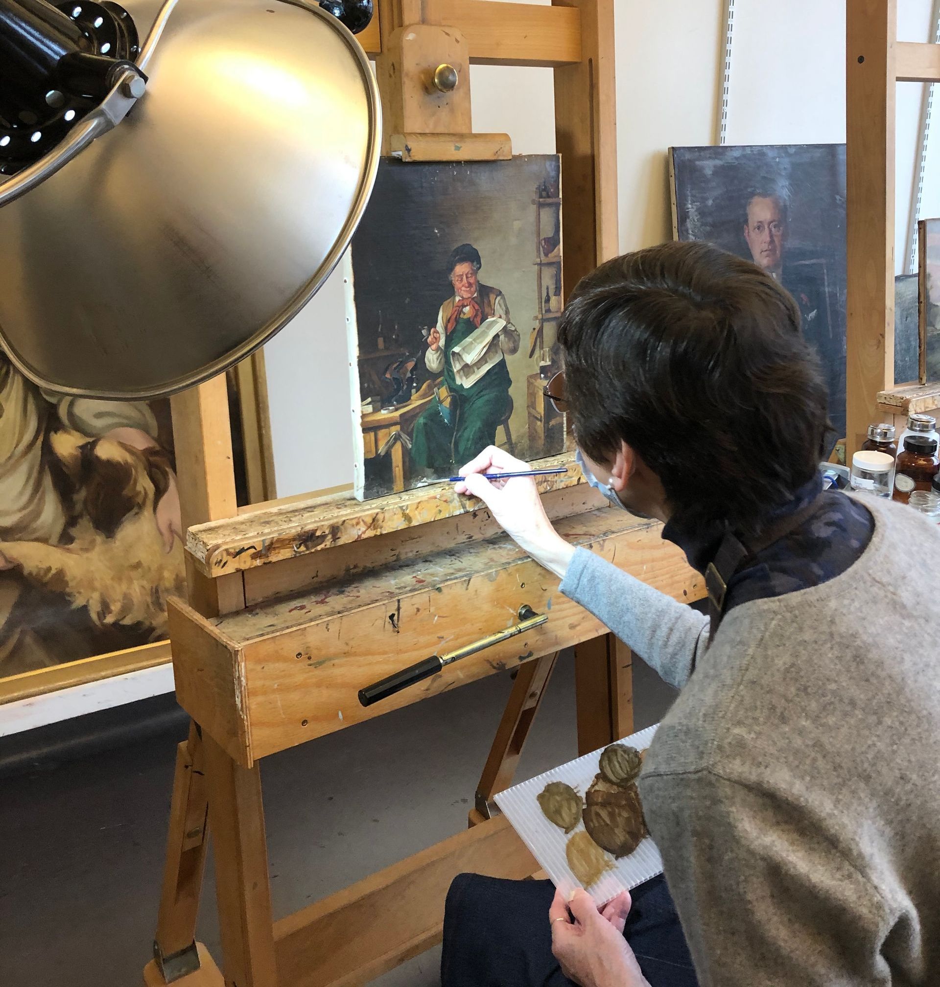 A woman wearing purple gloves is working on a red object