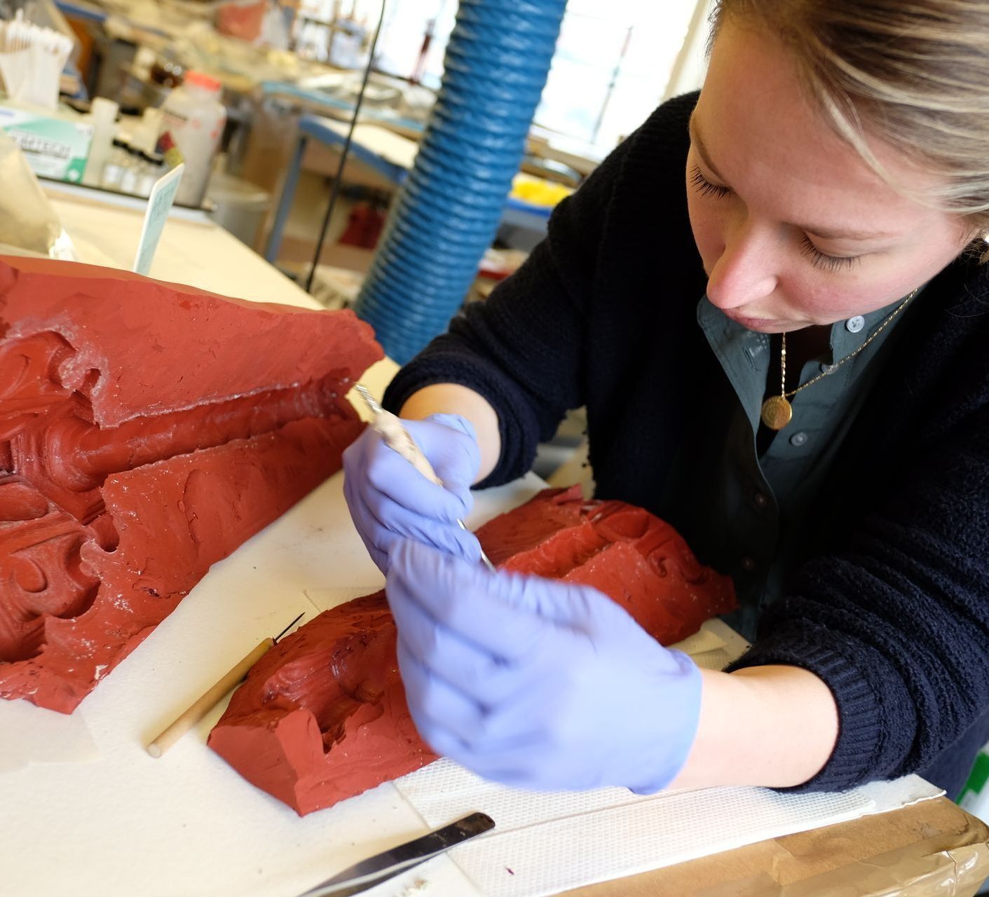 A woman is working on a piece of paper on a wooden table