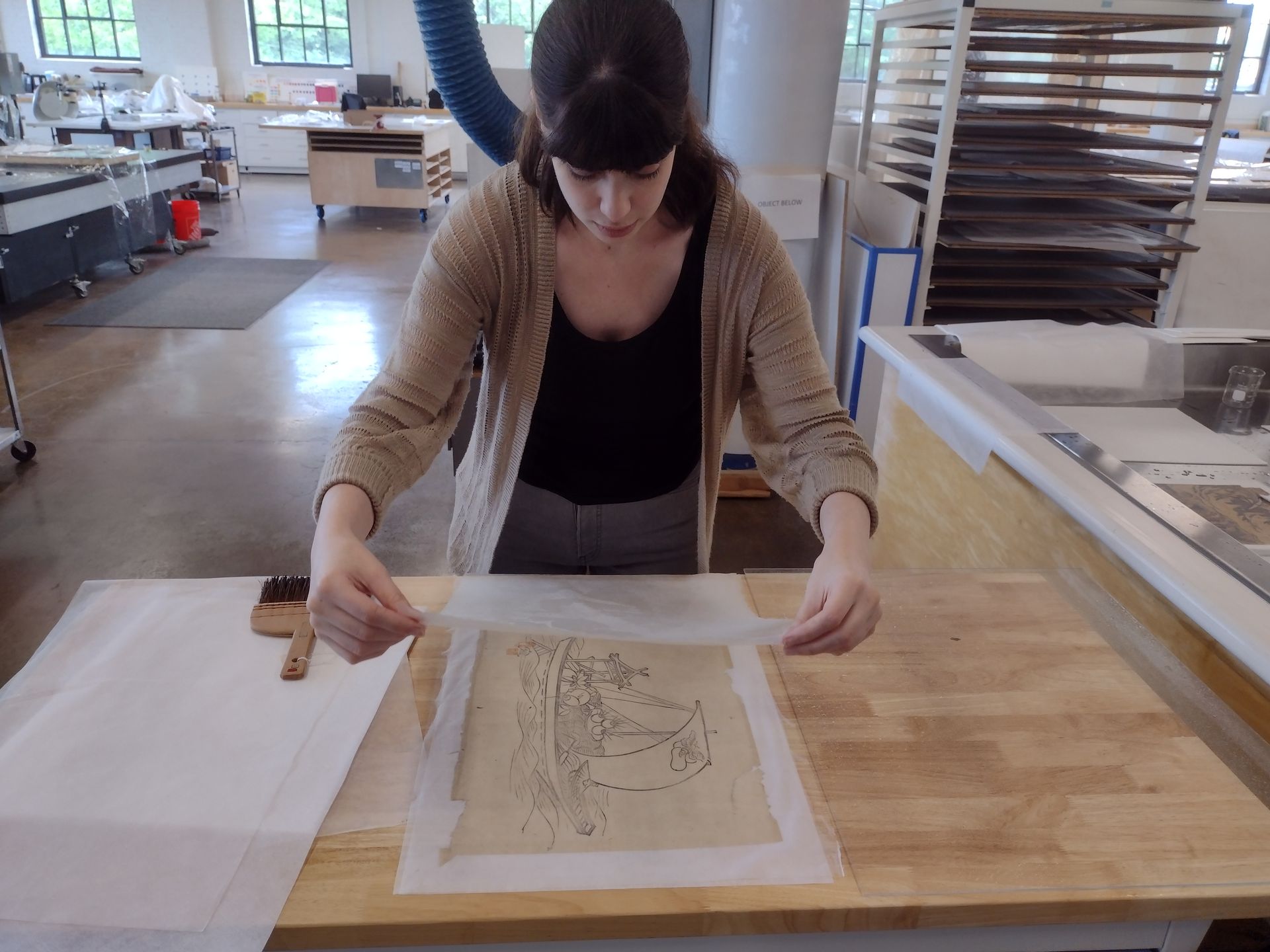 A man is painting a picture on an easel in a studio.