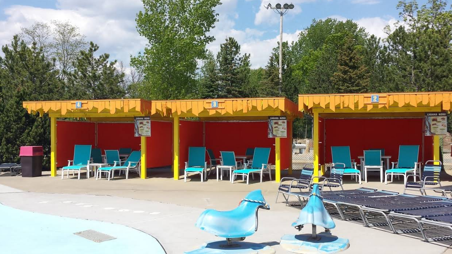 A row of chairs are lined up in front of a pool.