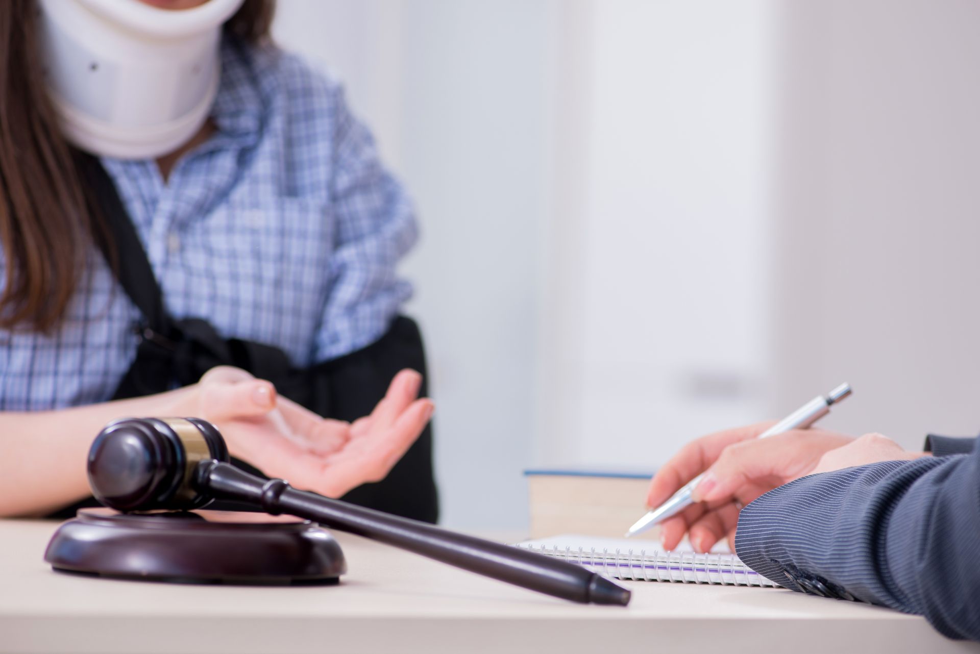 lady with accident neck and arm talking to a lawyer