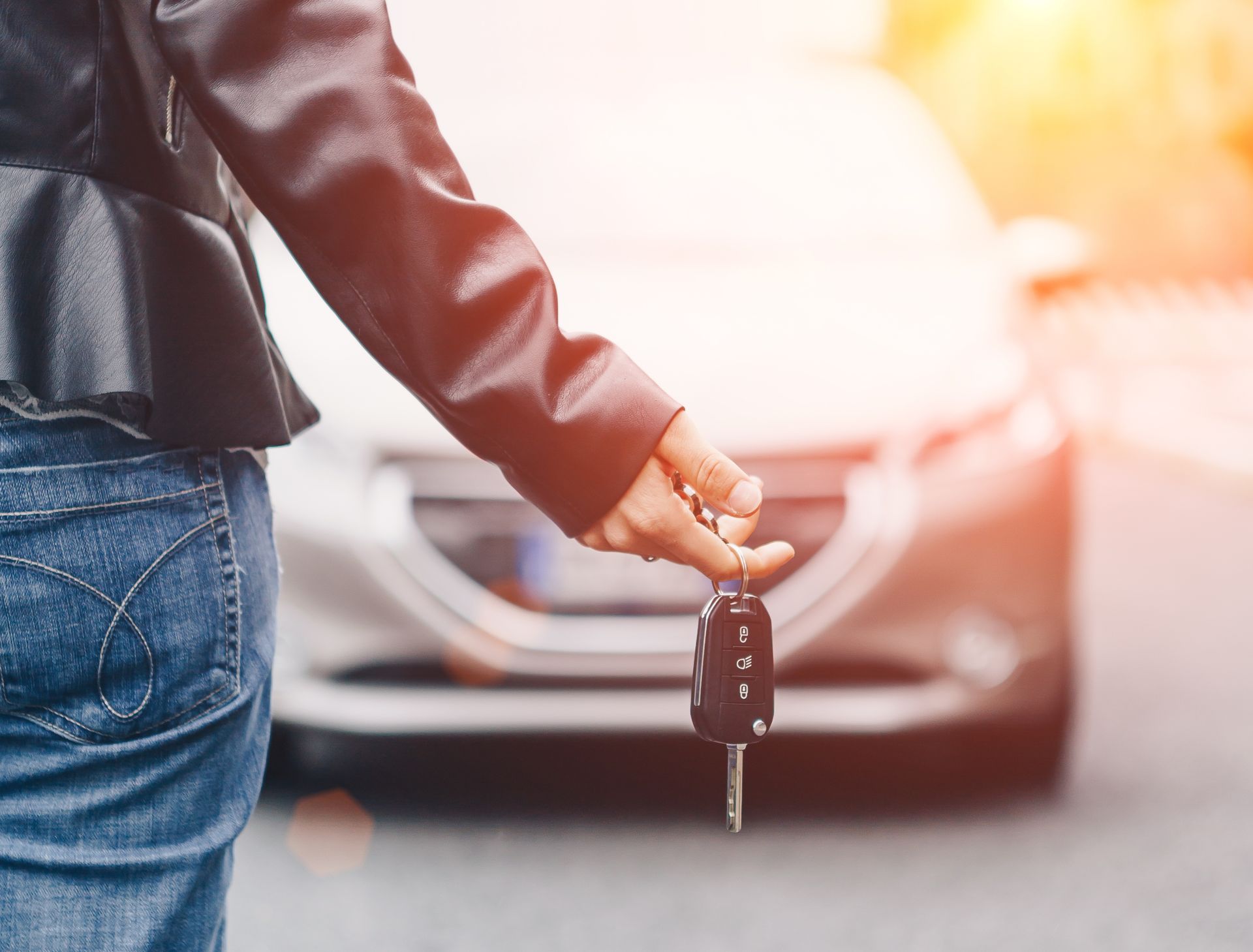 lady holding car key background blurry car