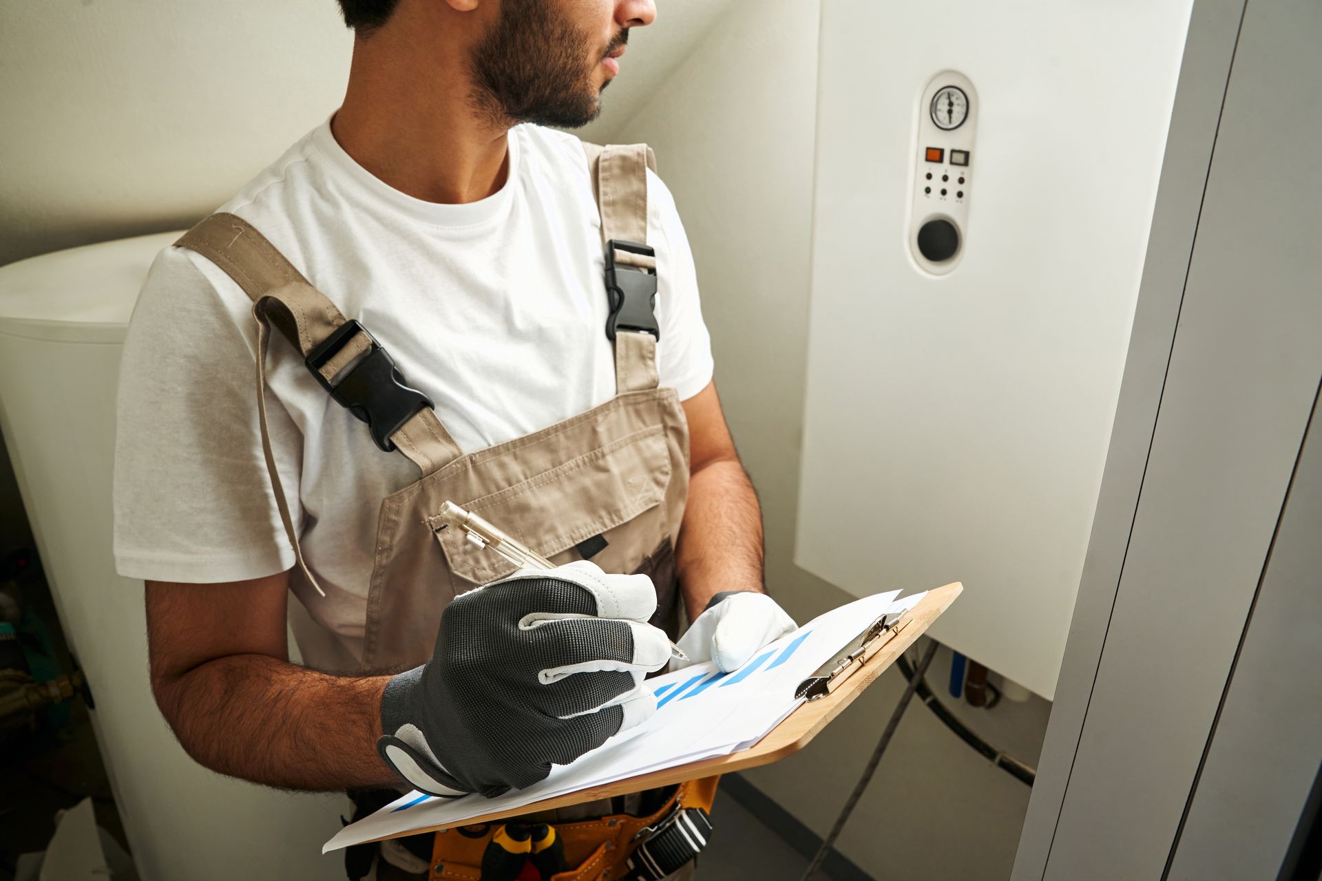 A man is holding a clipboard and writing on it.