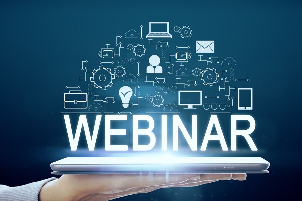 A person is holding a tablet with the word webinar on it.