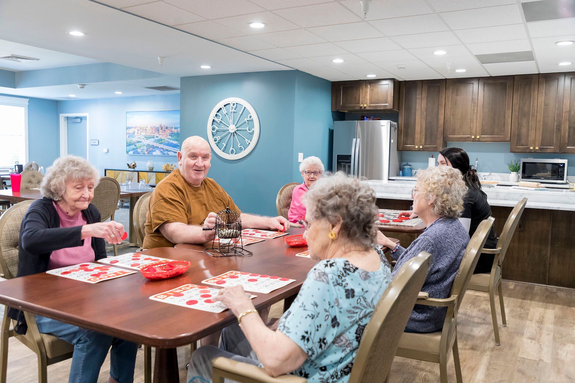 A group of elderly people are sitting around a table playing a game.