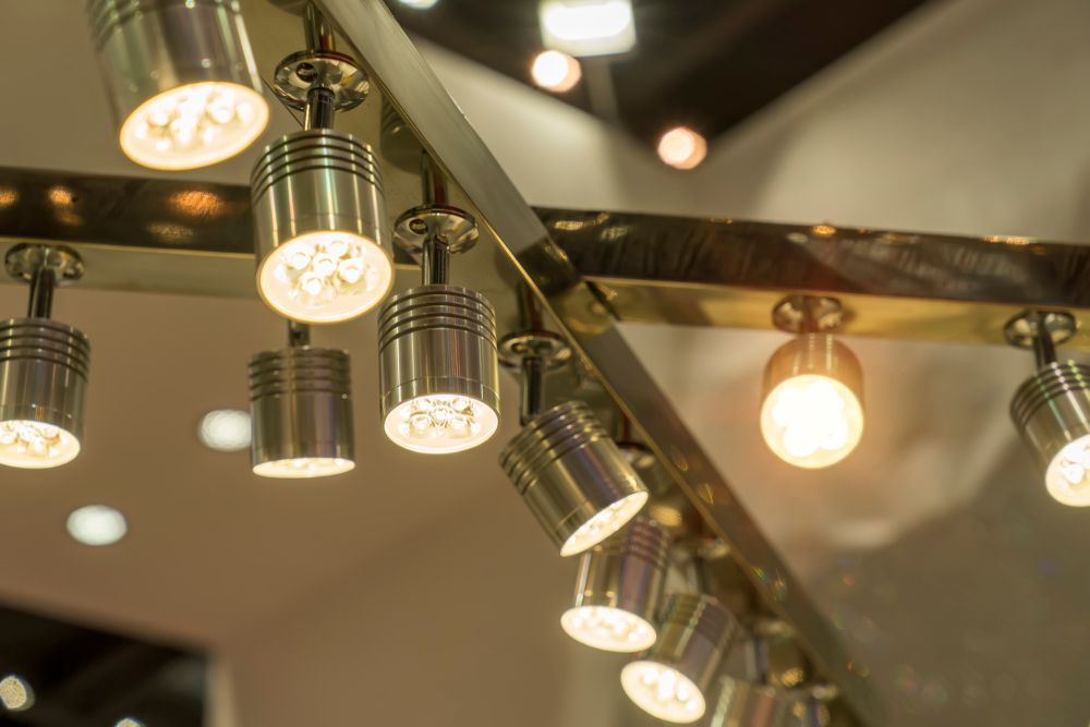 Close-up of a track lighting system with several spotlights illuminating a room.
