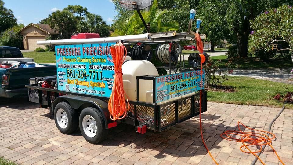 A trailer with power washing equipment parked on a driveway. 