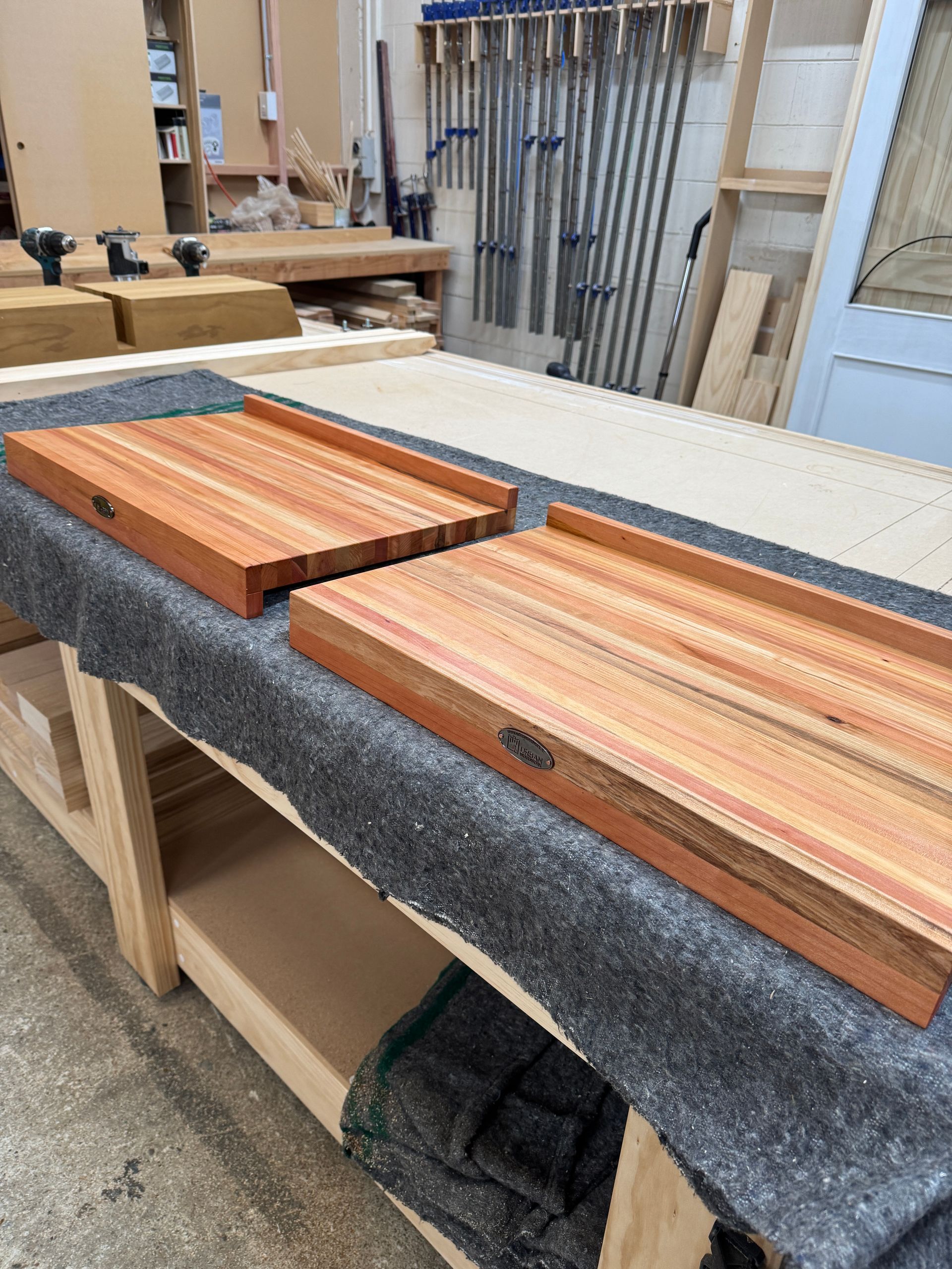 Two wooden pasta boards are sitting on top of a wooden table.
