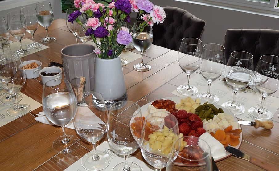 A wooden table topped with plates of food and wine glasses.