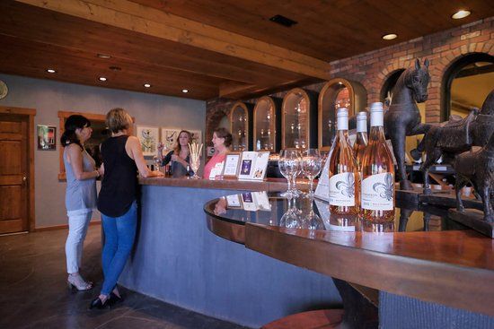 A group of women are standing at a counter in a winery.