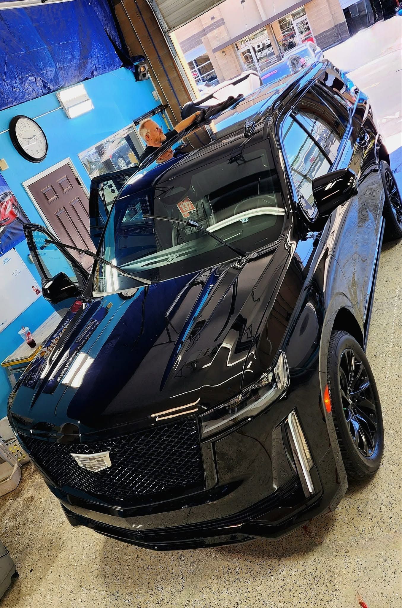 Black sports car in an indoor showroom with blue walls and bright lighting