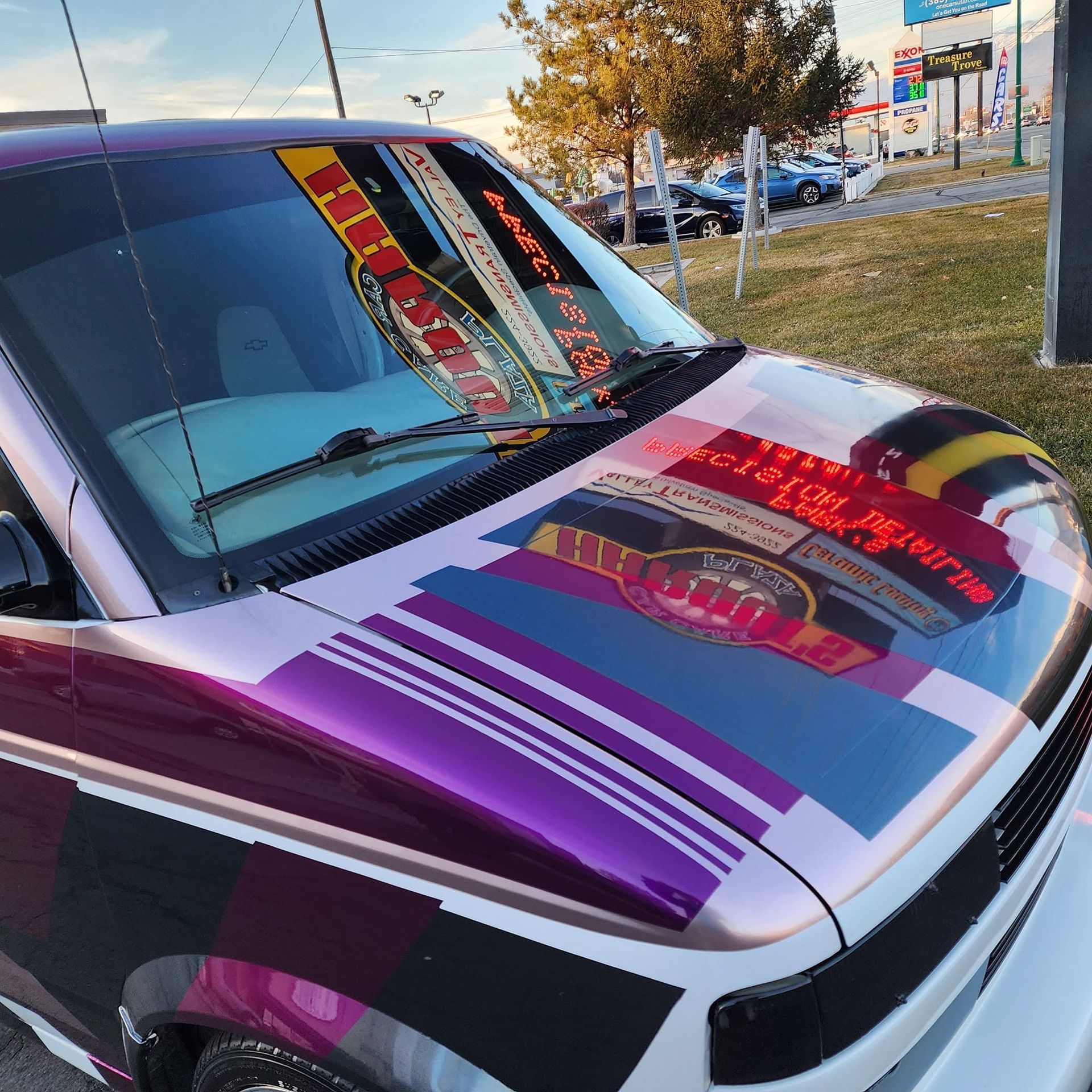 Custom purple, white, and black car hood with bold graphic stripes parked outdoors
