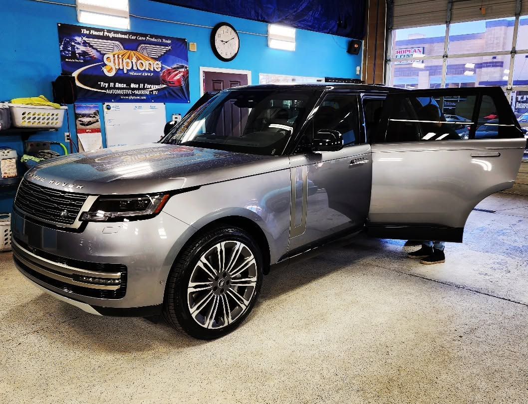 Silver SUV on display indoors with the driver door open in a showroom.