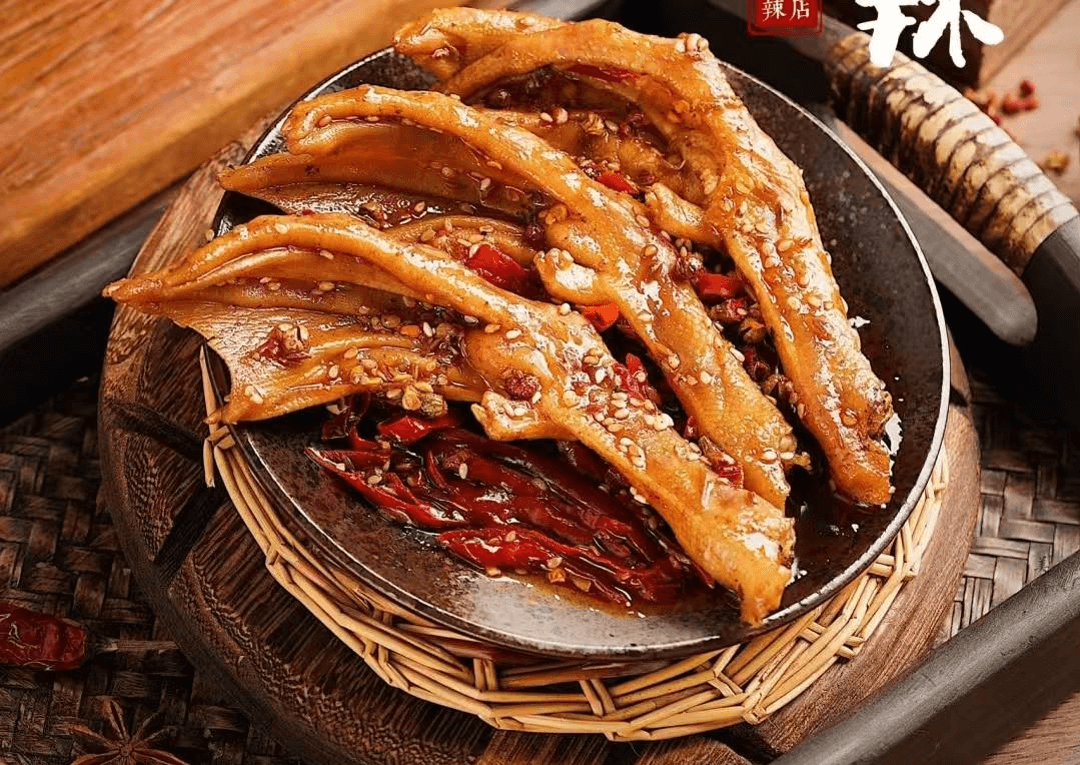 Grilled eel fillets on a woven tray with red chili peppers and glossy sauce