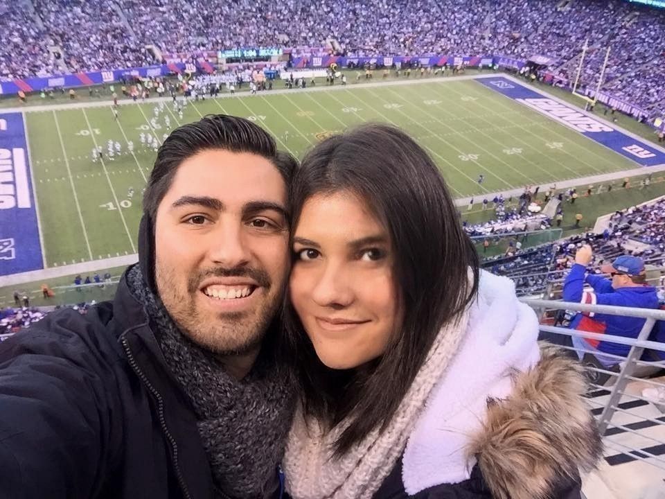 Un hombre y una mujer posan para una fotografía en un partido de fútbol.