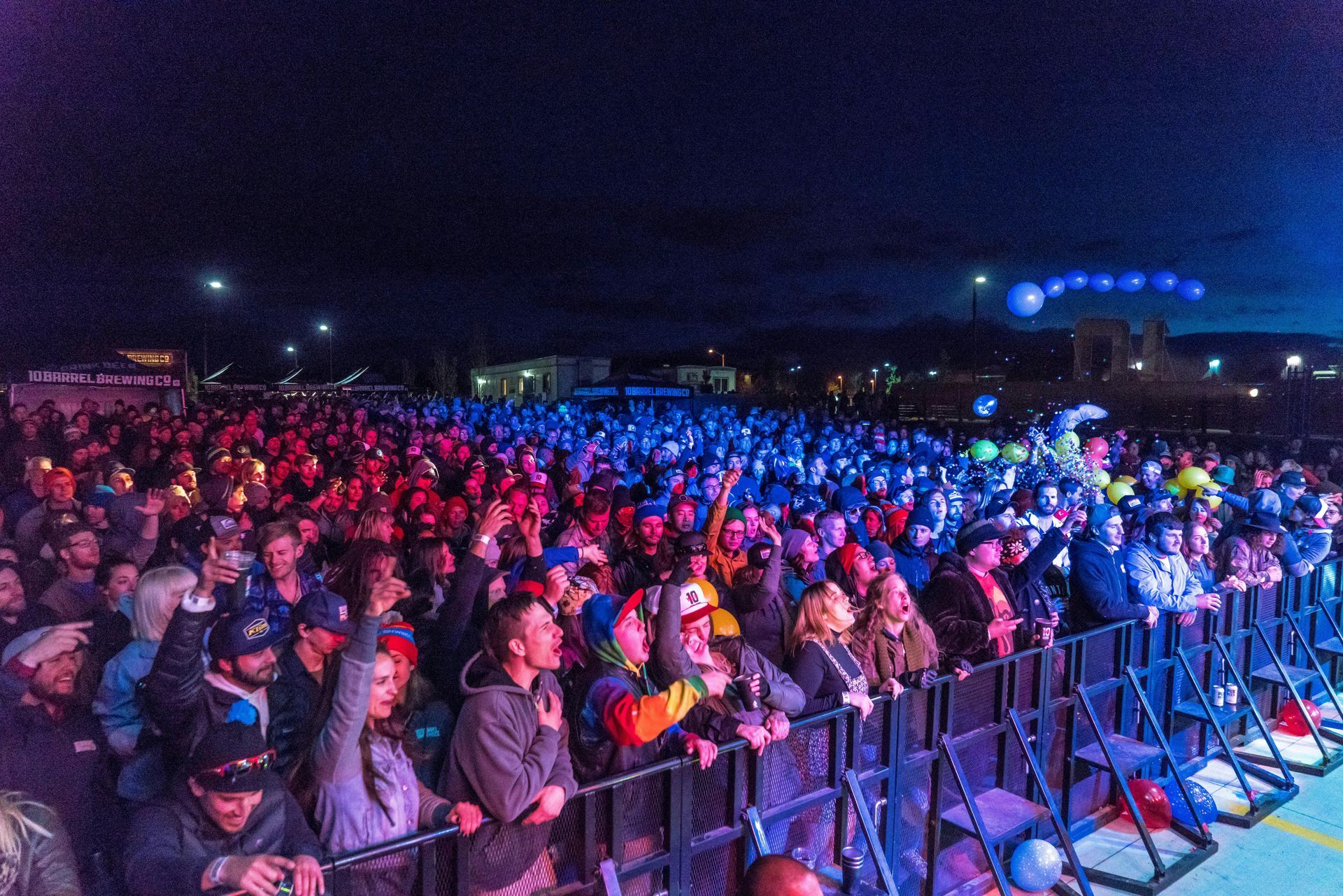Una gran multitud de personas está parada frente a un escenario en un concierto.