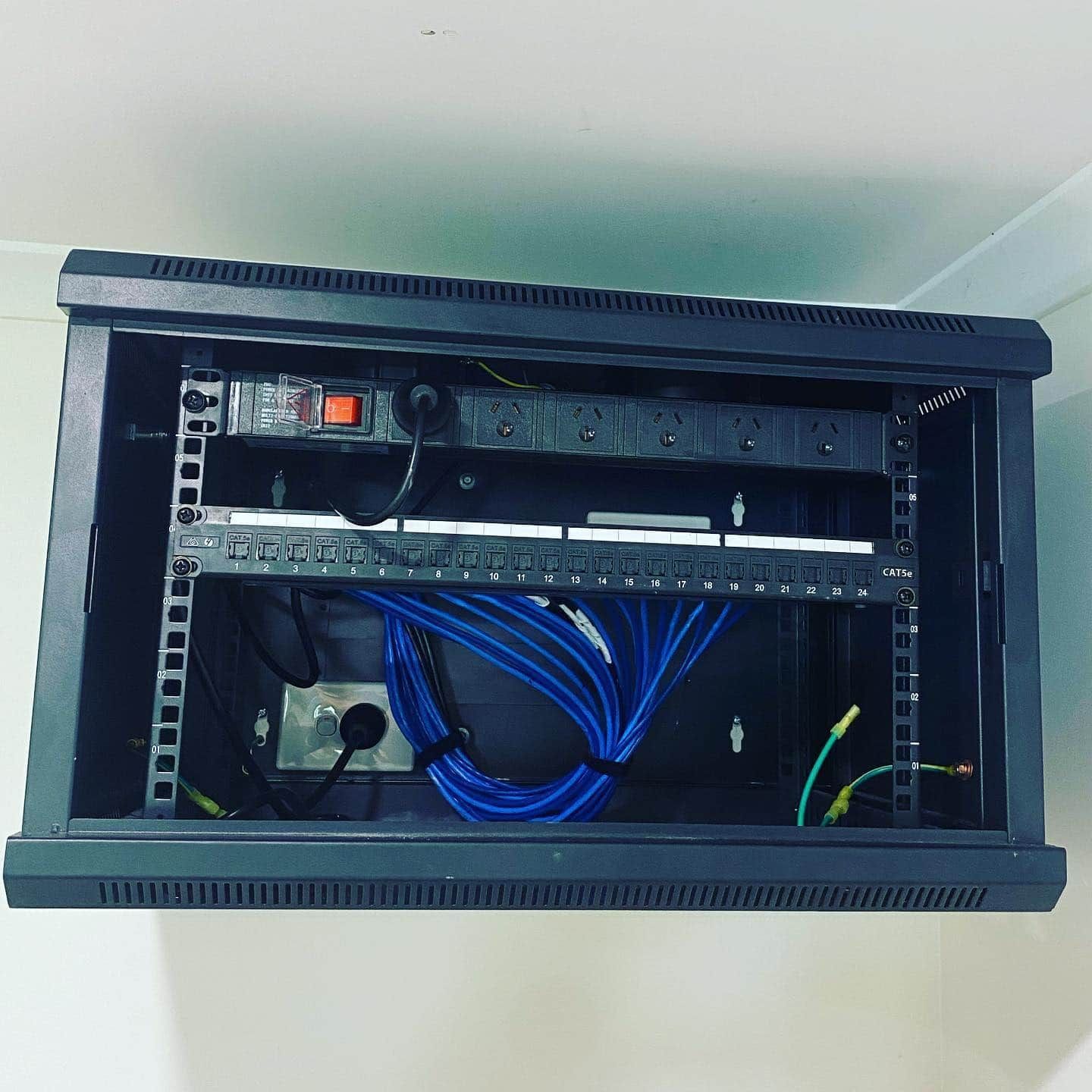 A Server Rack with A Bunch of Wires Coming out Of It — Higgins Electrical in Landsborough, QLD
