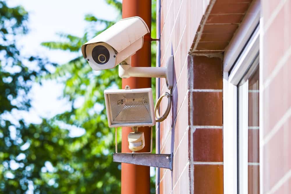 A Security Camera Is Mounted on The Side of A Brick Building — Higgins Electrical in Beerwah, QLD