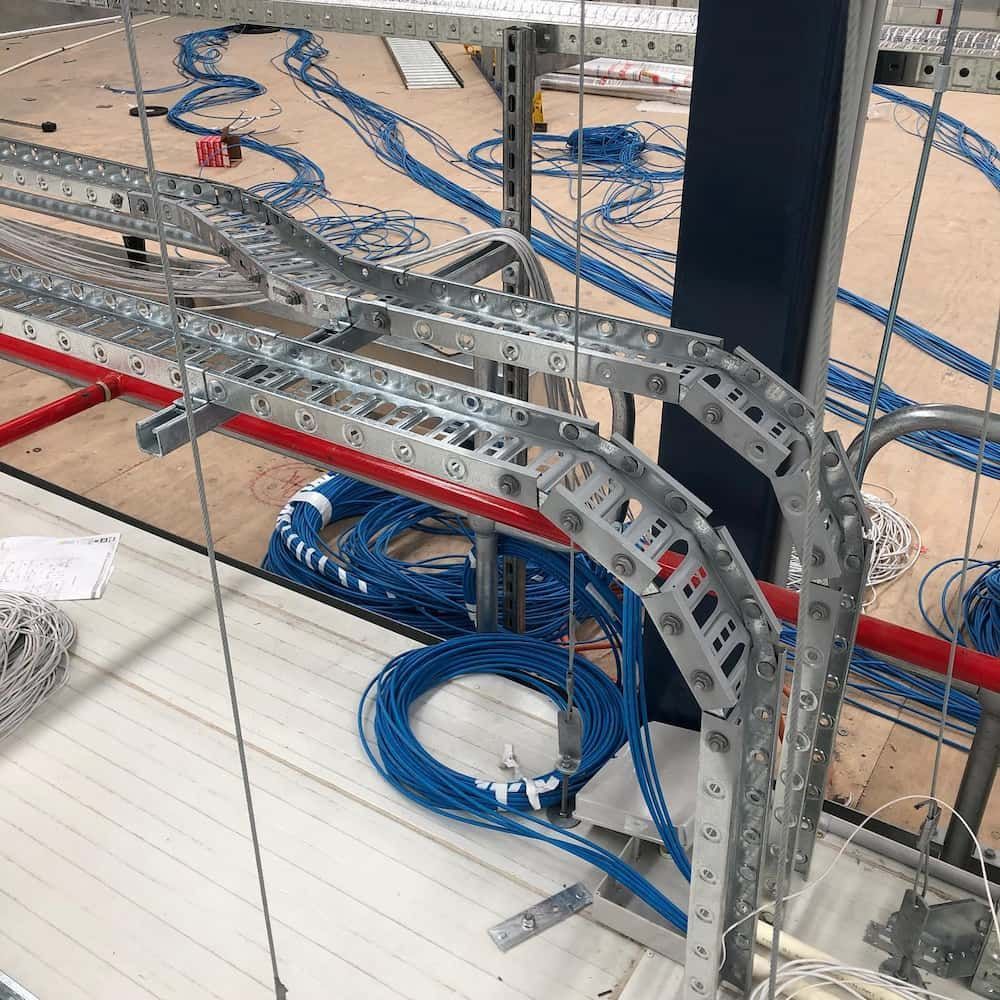 A Bunch of Wires Are Hanging from A Metal Structure — Higgins Electrical in Glenview, QLD