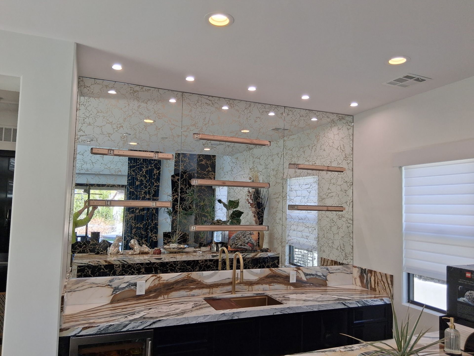 Modern bathroom with marble vanity, large mirror, and recessed lighting