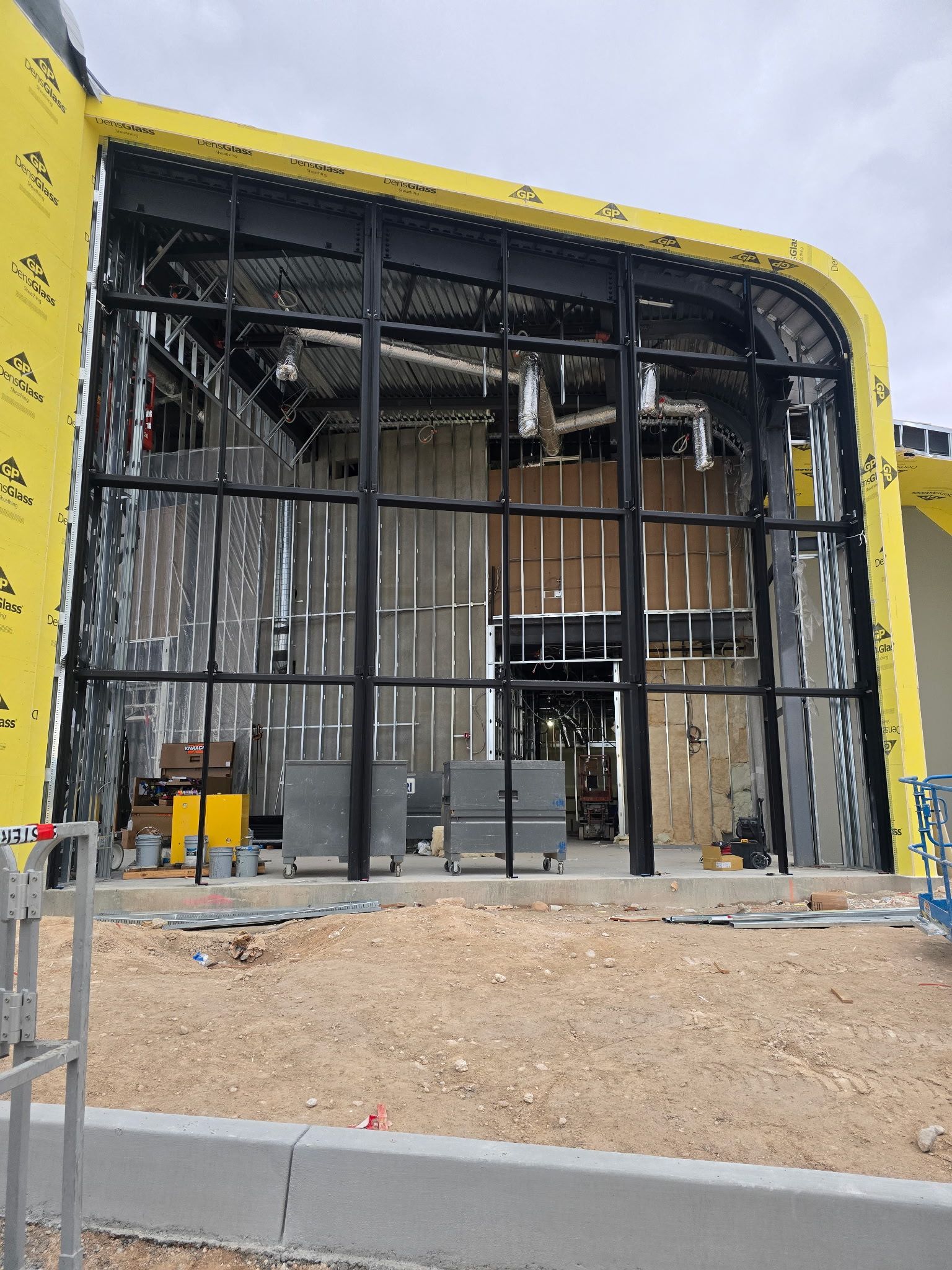 Construction site with a yellow-framed building facade under renovation and scaffolding inside