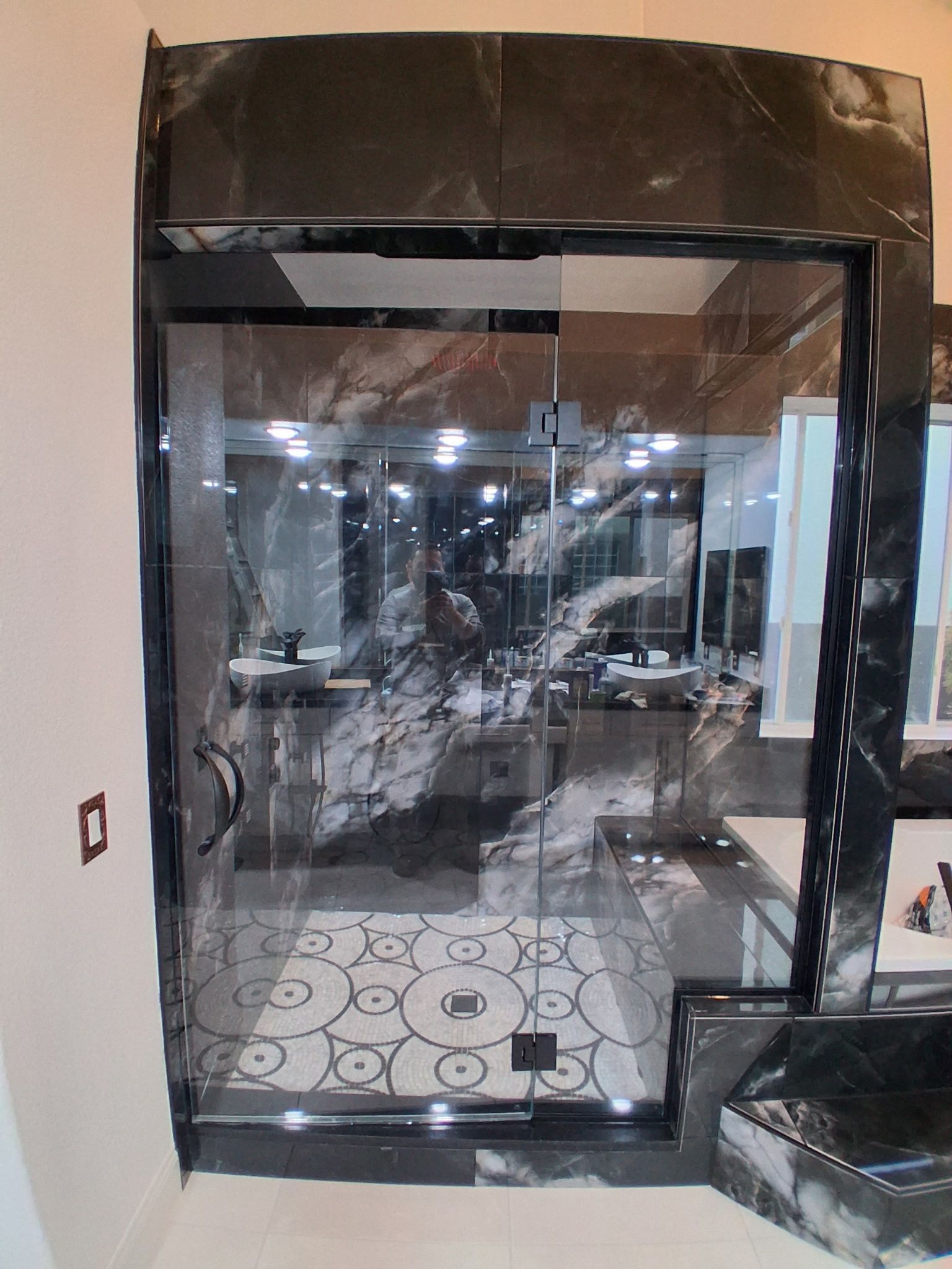Glass-fronted room under construction with tiled floor and reflective black framing