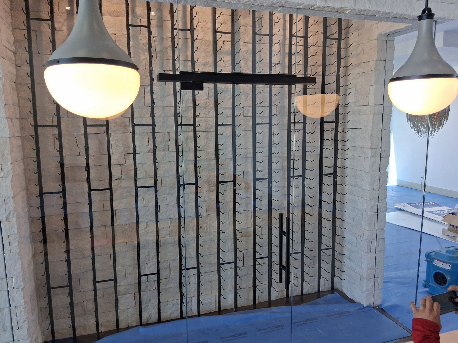 Small brick-lined room with three hanging lamps and a blue floor.