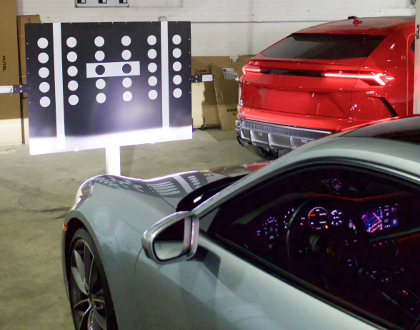 A silver car is parked next to a red car in a garage | Quantum Calibrations