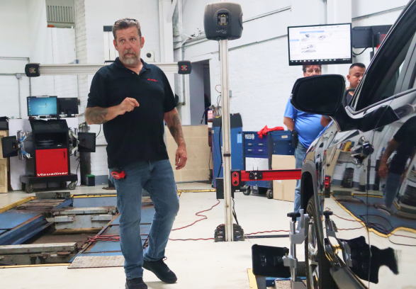 A man is standing next to a car in a garage | Quantum Calibrations