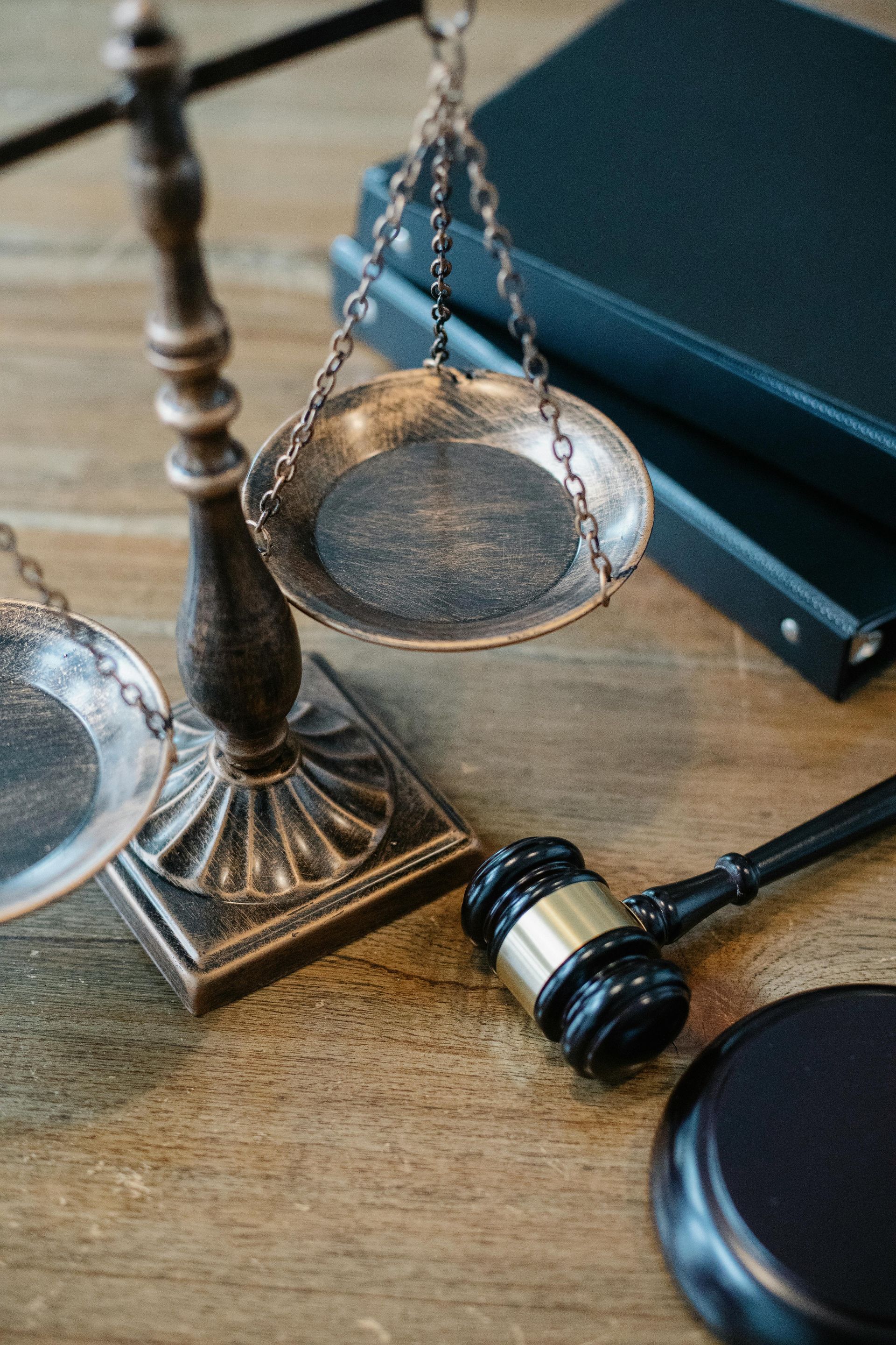 Scales of justice, gavel, and books on a wooden table.