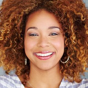 Smiling woman with curly auburn hair