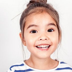 Smiling child with dark hair in a blue-and-white striped shirt