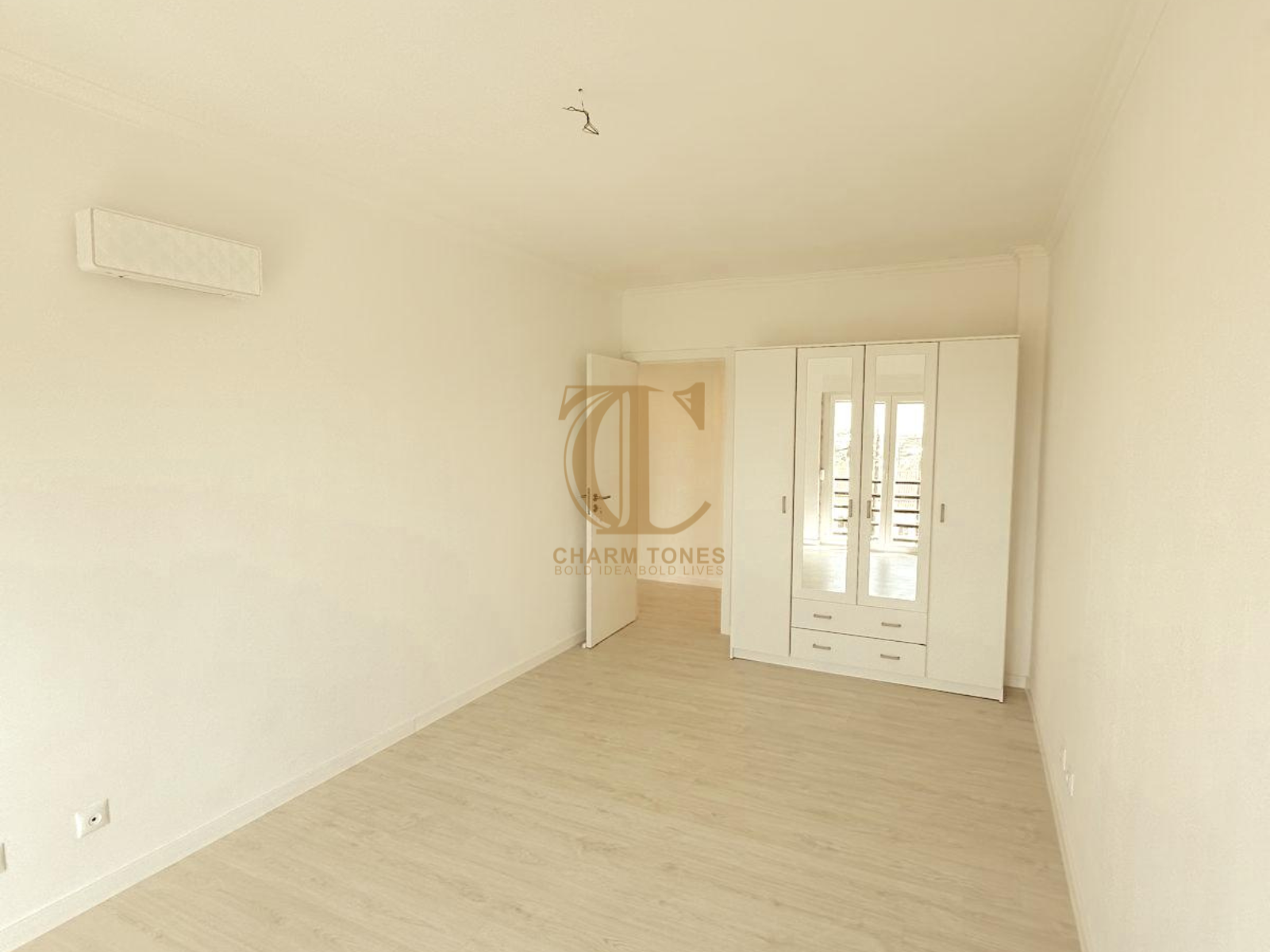 Um quarto vazio com paredes brancas e um guarda-roupa