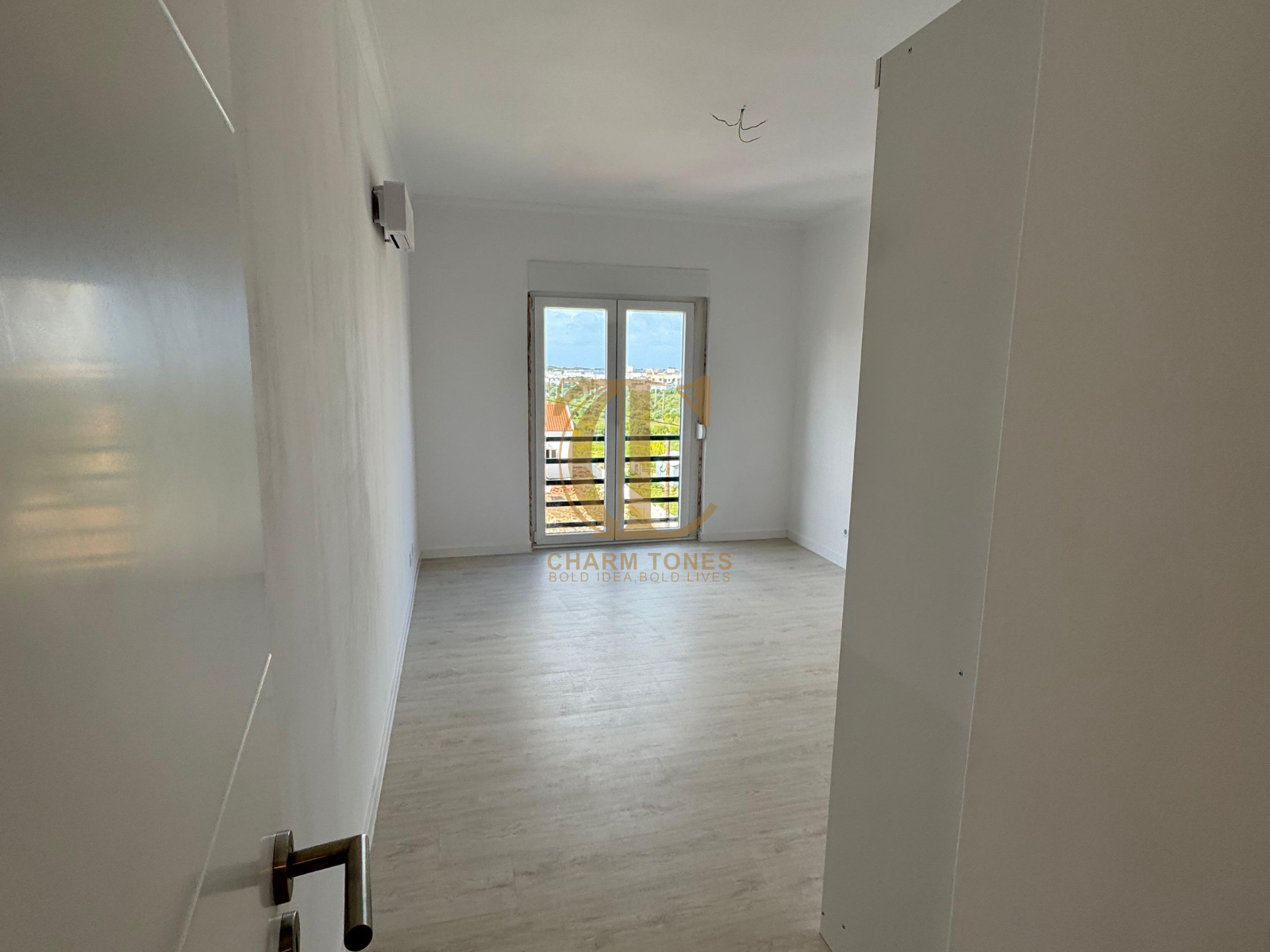 Uma sala vazia com uma janela e uma porta.
