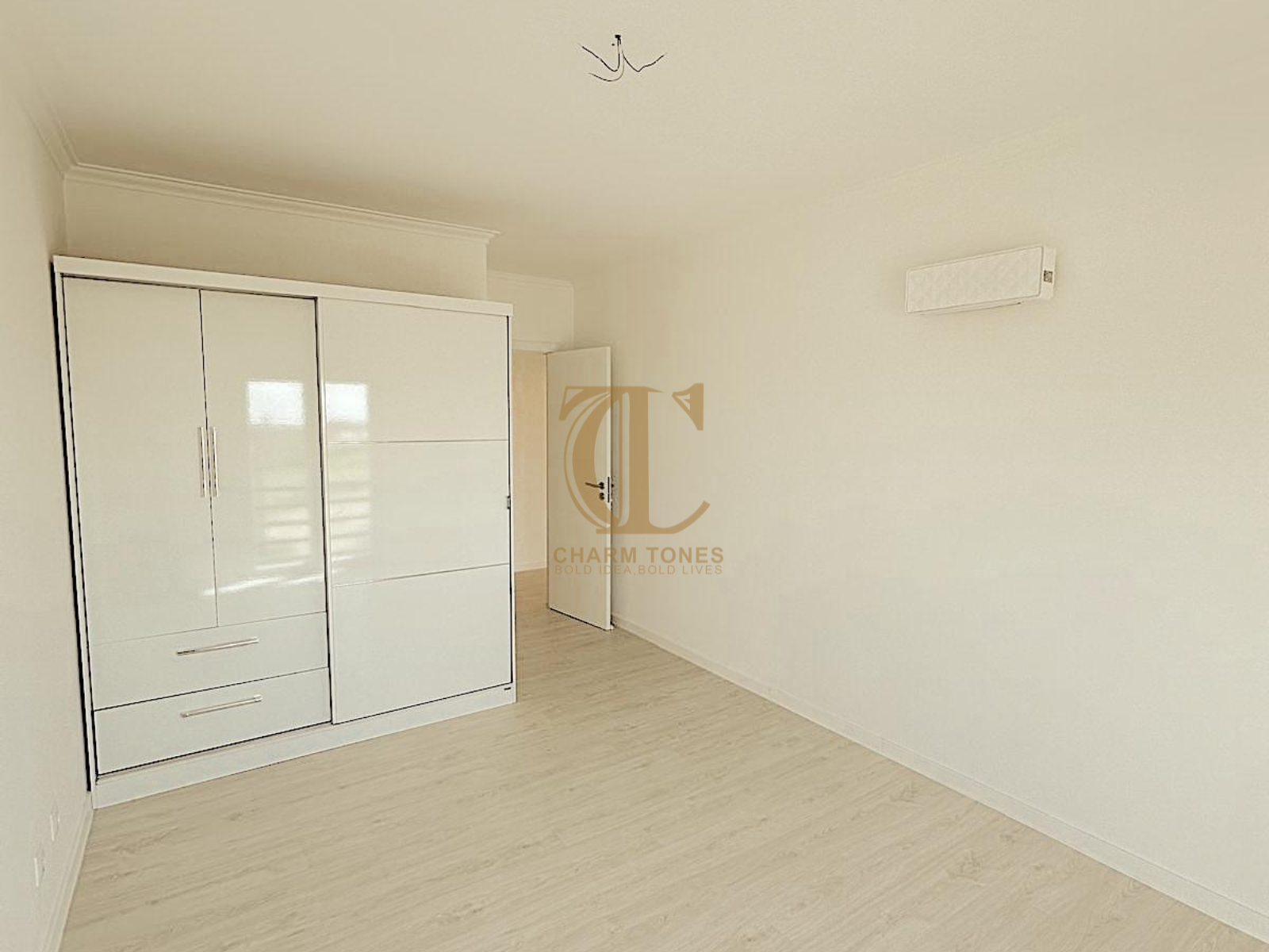 Um quarto vazio com um grande guarda-roupa e uma janela.