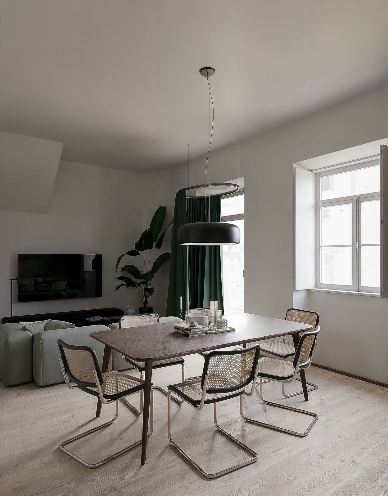 Um quarto minimalista com piso de madeira clara, uma cama baixa com roupa de cama branca e armários embutidos em tom cinza claro.