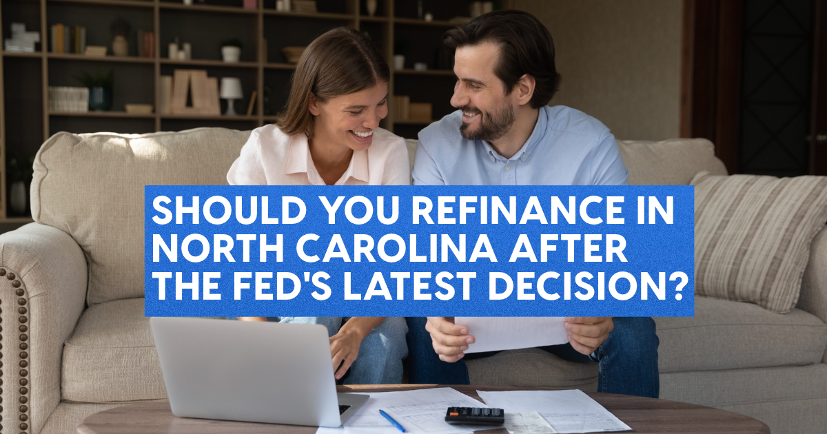 Smiling couple reviewing refinance paperwork with a laptop and calculator on their couch