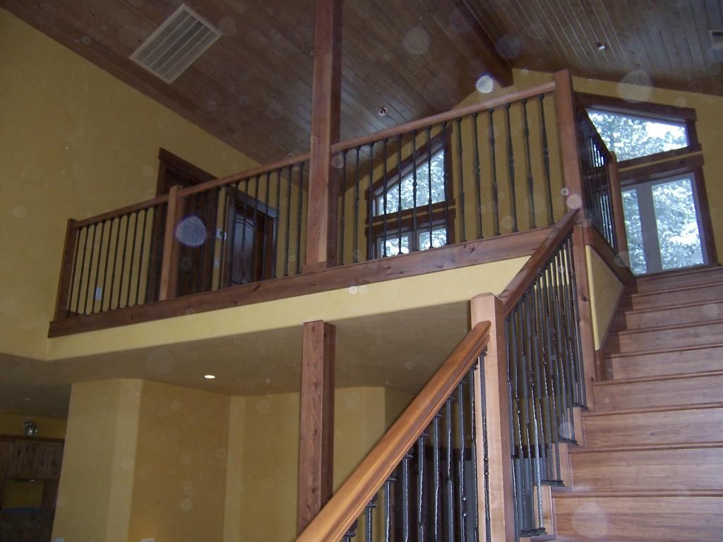 A wooden staircase with a metal railing in a house
