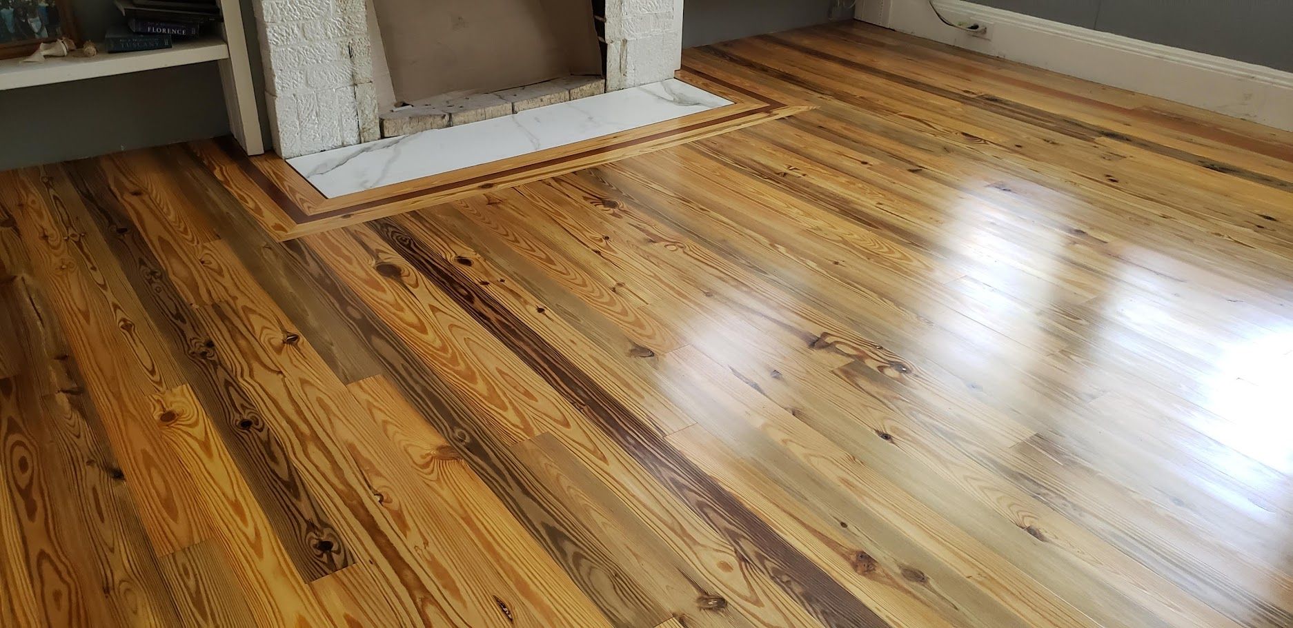 Sunlit hardwood floor with rustic plank patterns in an empty room