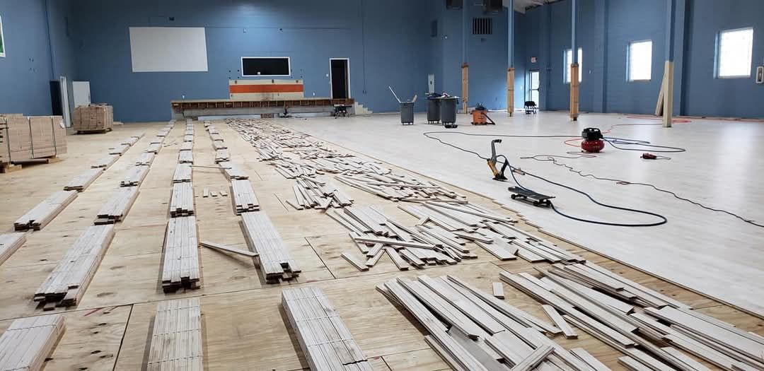 Empty warehouse with long rows of lumber and construction materials on a concrete floor